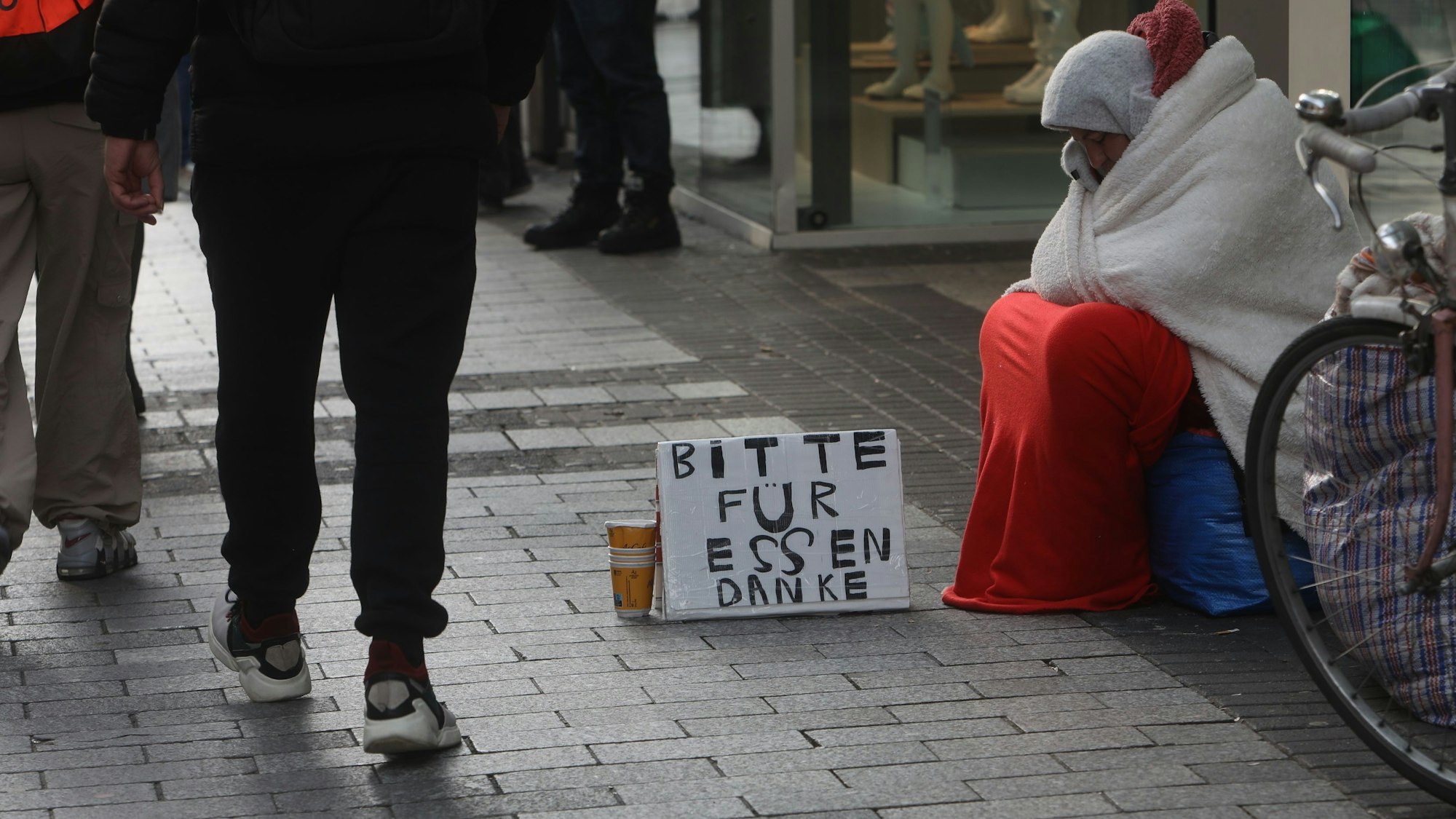 31.01.2025, Köln: Betteln mit System: Fast fast immer gleicher Wortlaut und Schrift auf den Kartons. Foto: Arton Krasniqi