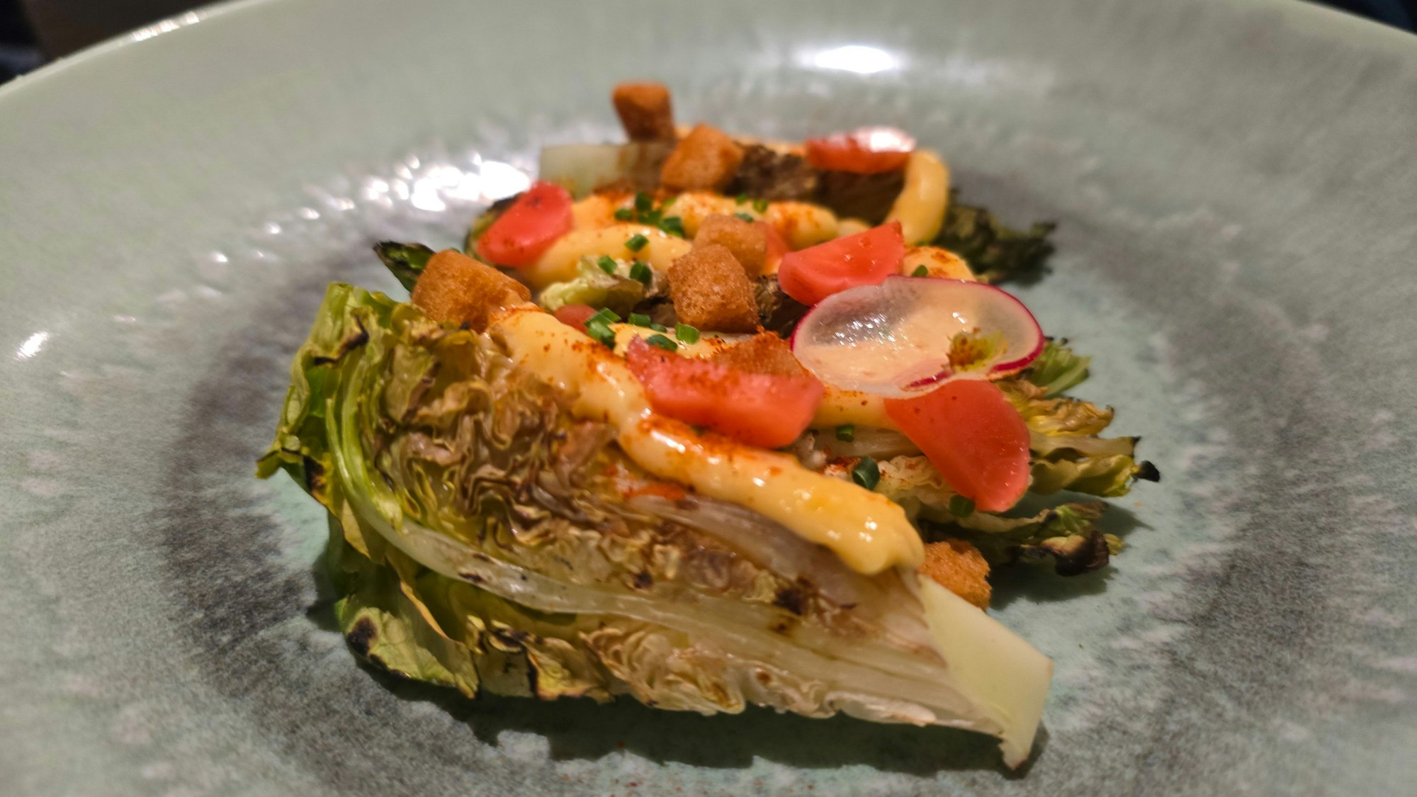 Tellergericht mit Salatviertel und anderen bunten Zutaten