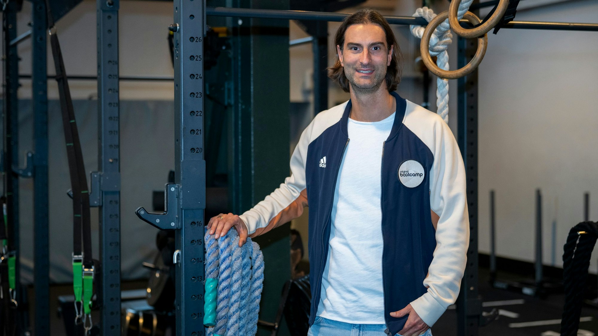 Nils Barkhoff, Geschäftsführer von original Bootcamp, steht vor Sportgeräten.