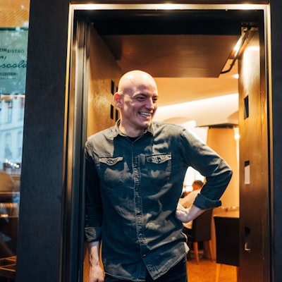 Ein Mann steht lächelnd in einem Türrahmen.