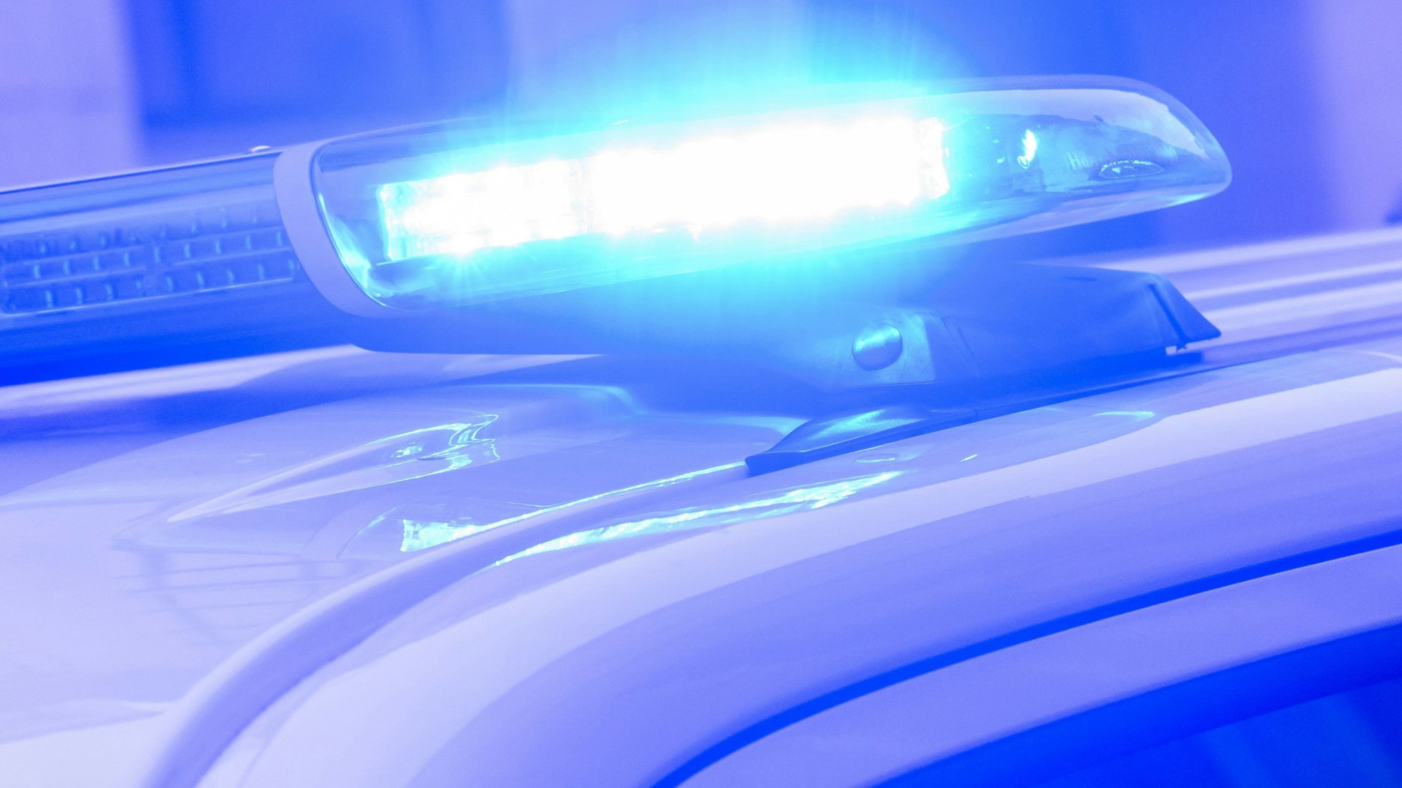 Ein Blaulicht leuchtet auf einem Einsatzfahrzeug der Polizei.