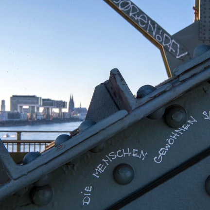 Das Bild zeigt einen kleinen Teil der Südbrücke. Im Hintergrund sind die Kranhäuser und der Kölner Dom zu sehen.
