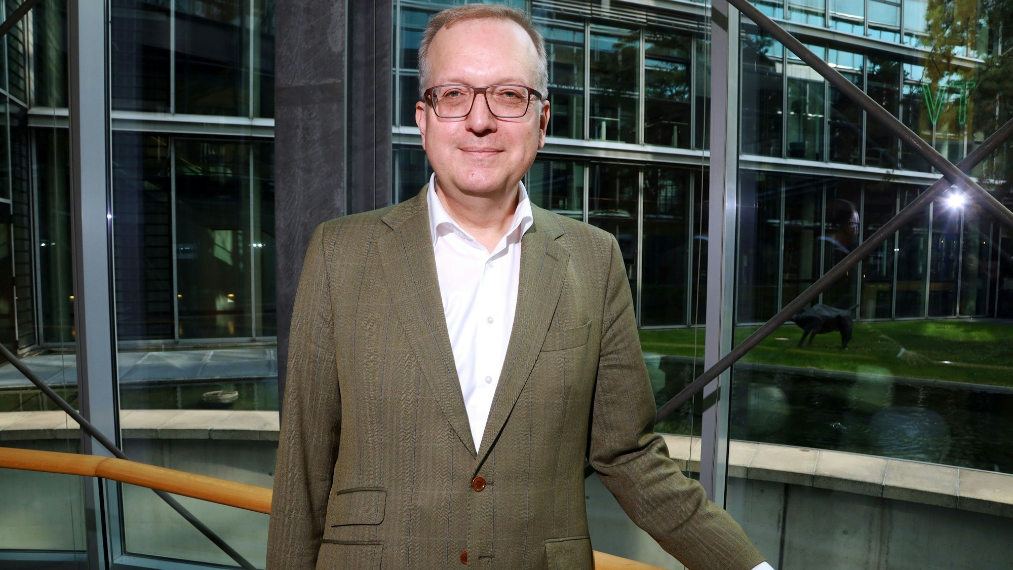 Markus Ogorek steht vor der inneren Glasfassade des Neven DuMont Haus