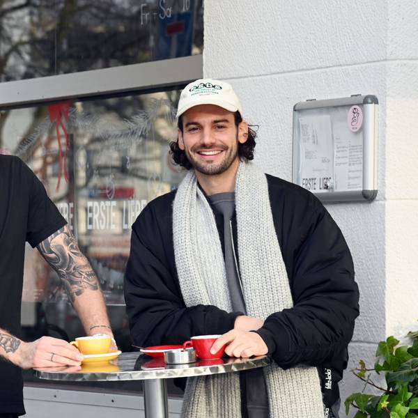 Chris Schneider und Tim Stutzenstein stehen an einem Stehtisch und trinken Kaffee.