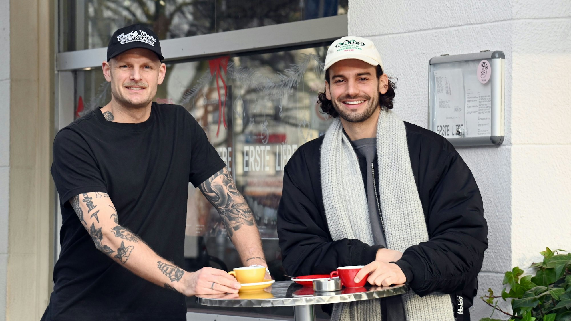 Chris Schneider und Tim Stutzenstein stehen an einem Stehtisch und trinken Kaffee.