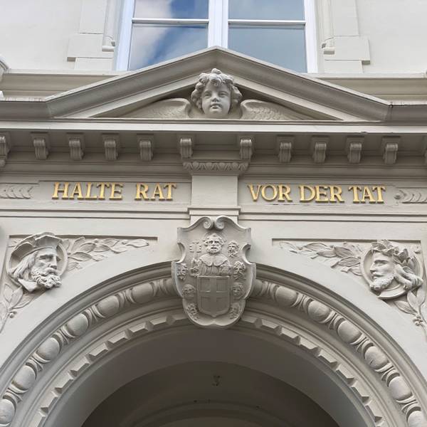 Zu sehen ist eine Inschrift am Brühler Rathaus. Sie lautet „Halte Rat vor der Tat“.