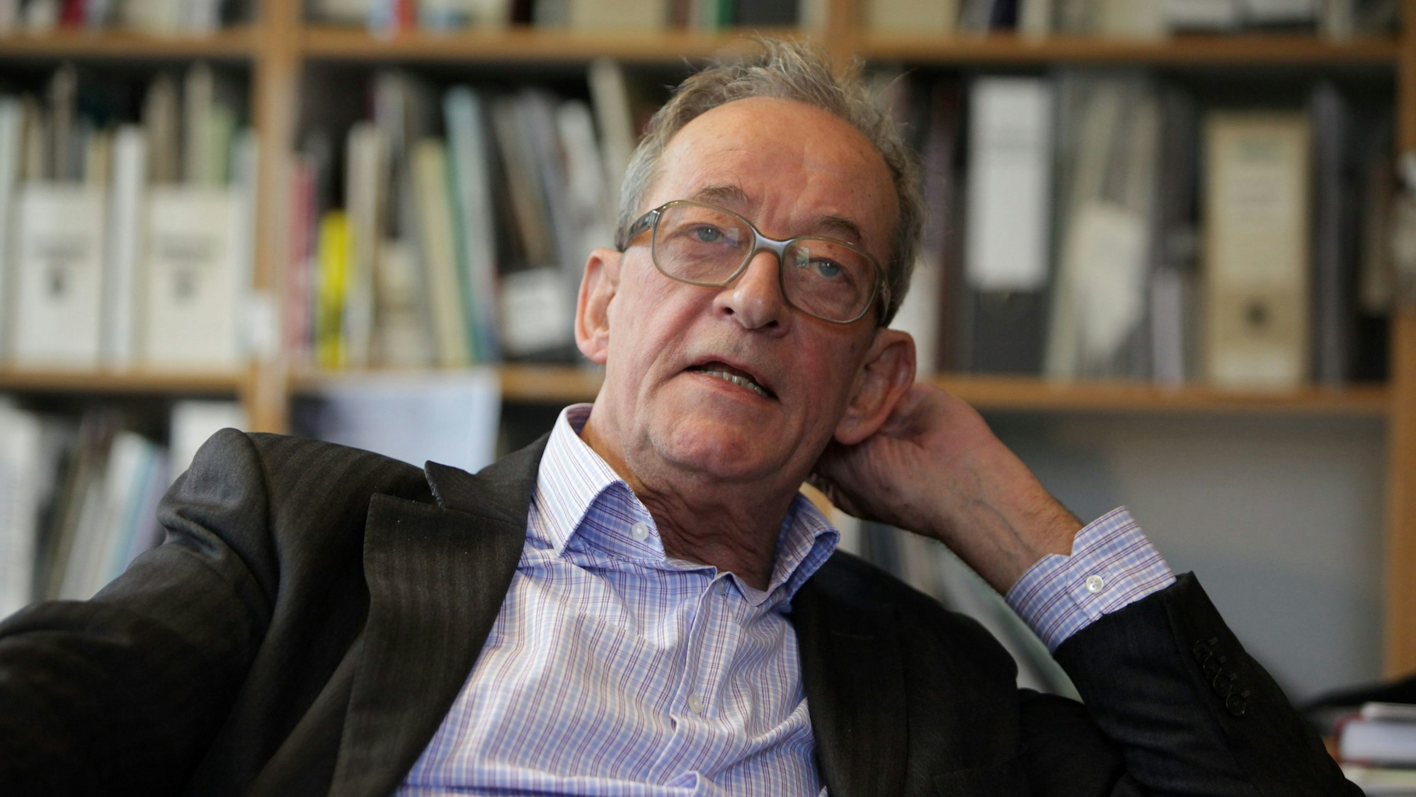 Kasper König lehnt sich entspannt zurück, während er spricht.