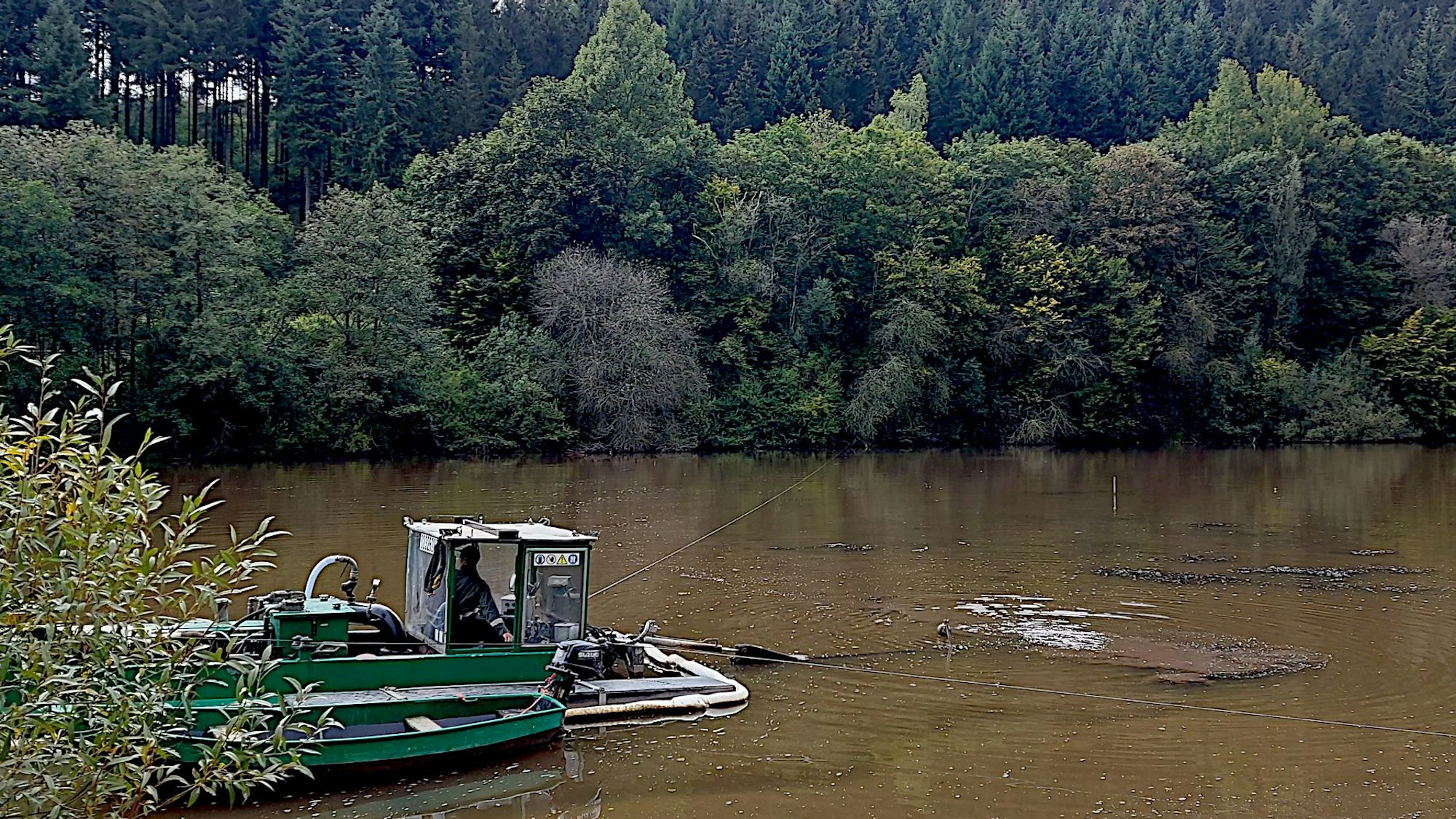 Ein Schwimmbagger ist im Vorstau des Kronenburger Sees im Einsatz. Er entfernt die Sedimente