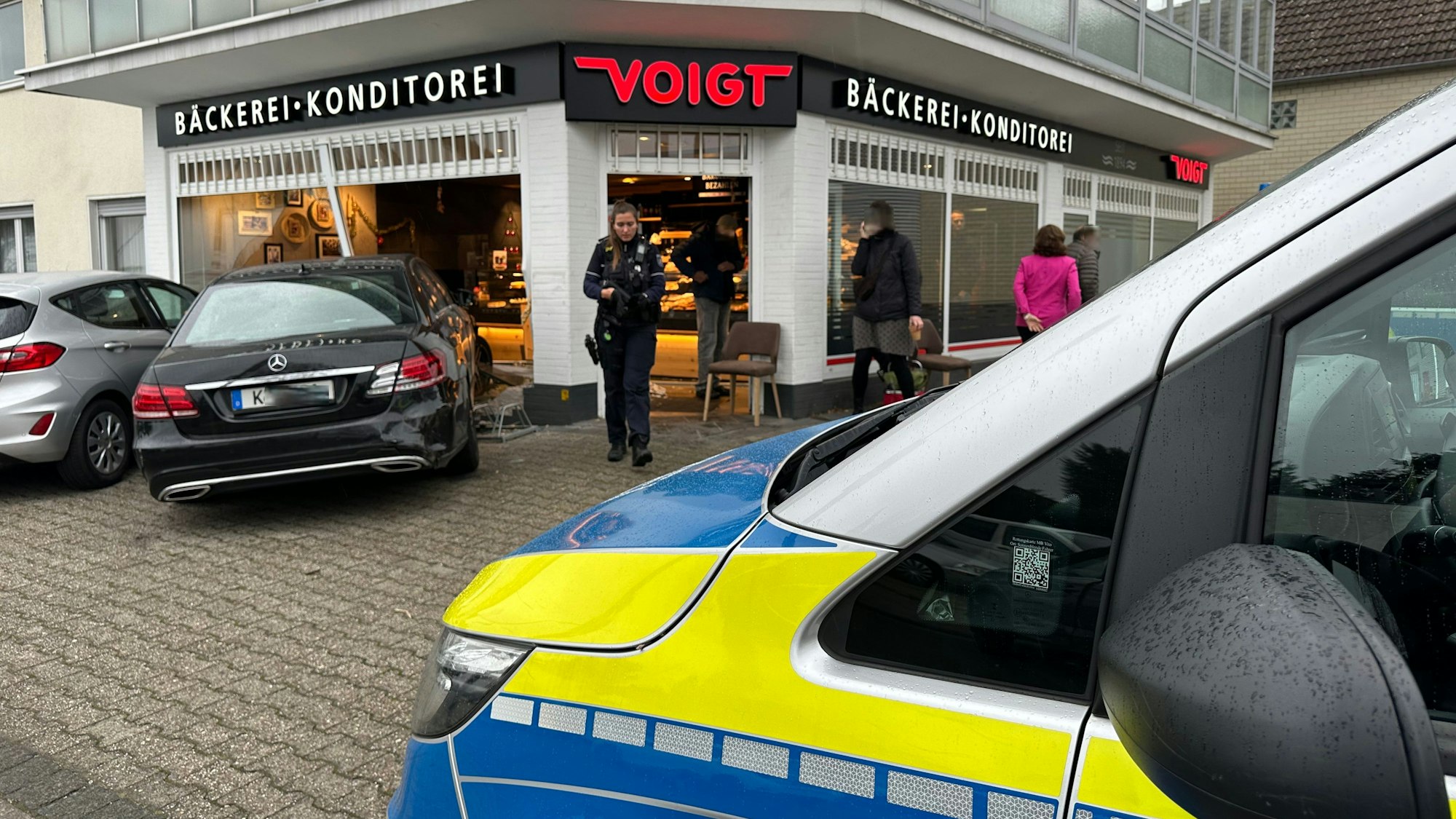 Ein in ein Bäckerei-Schaufenster gefahrenes Auto. Die Polizei ist vor Ort.