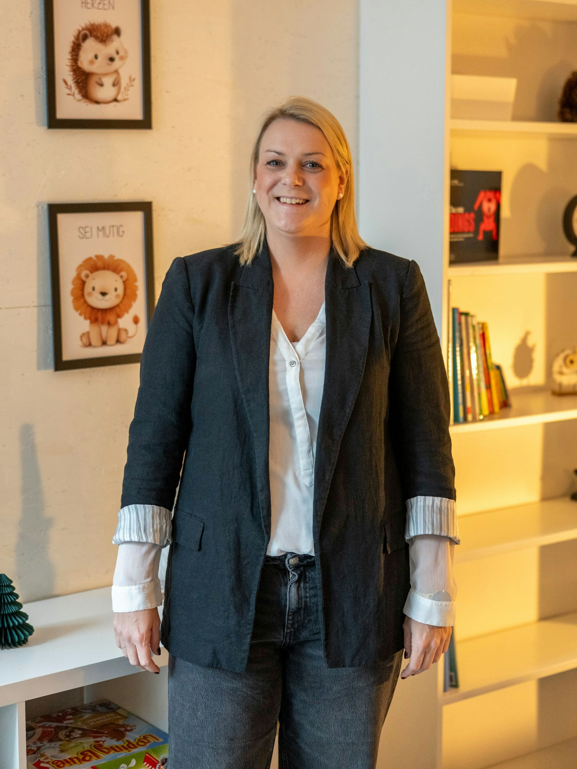 Nicole Bütow war arbeitslos und hat den Schritt in die Selbständigkeit gewagt. Sie hat ein Lerninstitut gegründet und berät Familien in schwierigen Situationen. Sie steht in einem Raum mit Kinder-Deko und lacht in die Kamera.