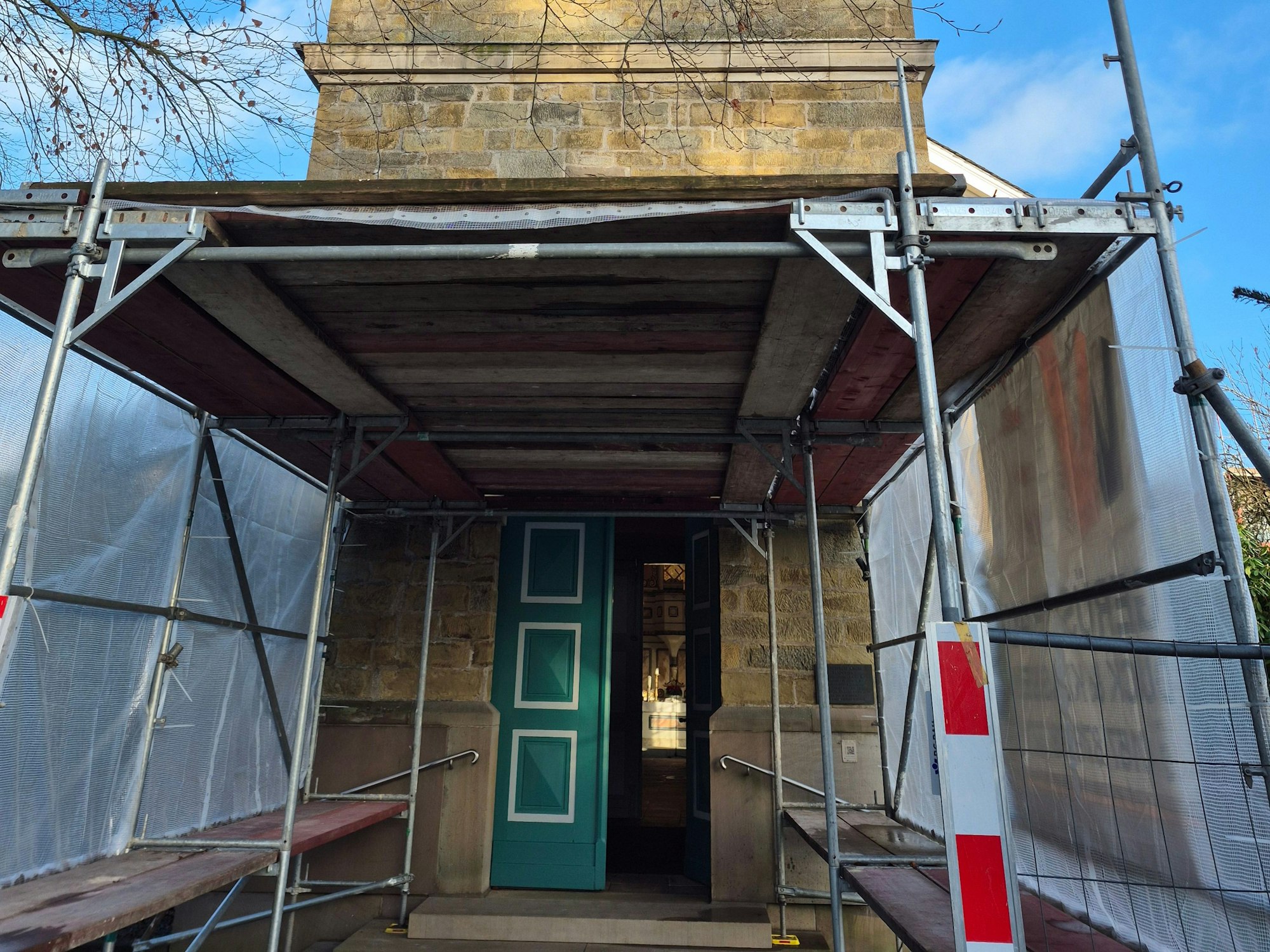 Außenansicht der Kirche in Klaswipper, mit dem eingerüsteten Eingang.