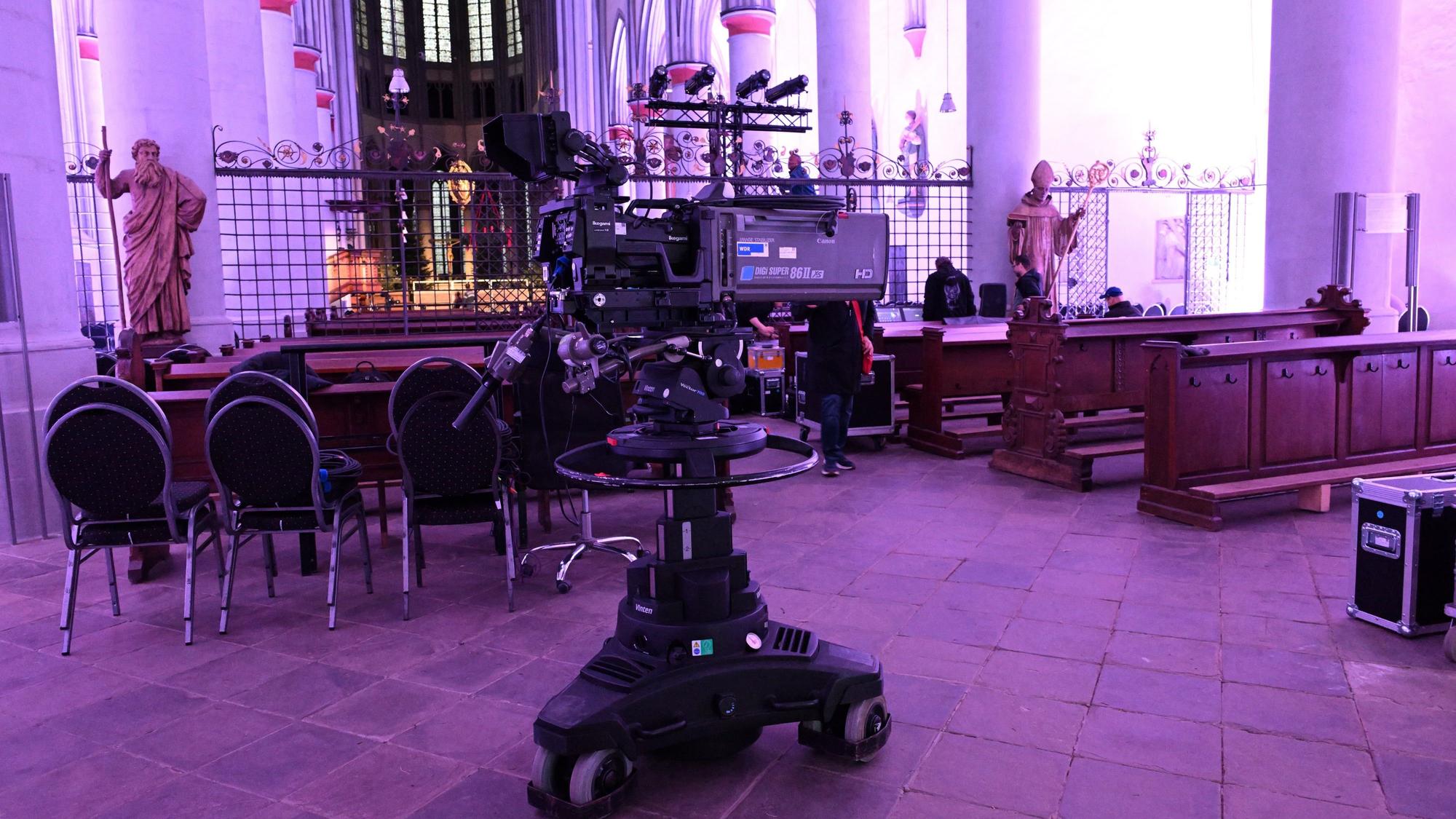 Eine Fernsehkamera steht mitten in einem violett ausgeleuchteten, gotischen Kirchenraum.