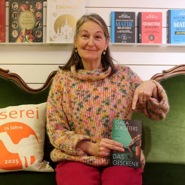 Das Bild zeigt Katharina Pütz, die auf einem grünen Sofa sitzt.