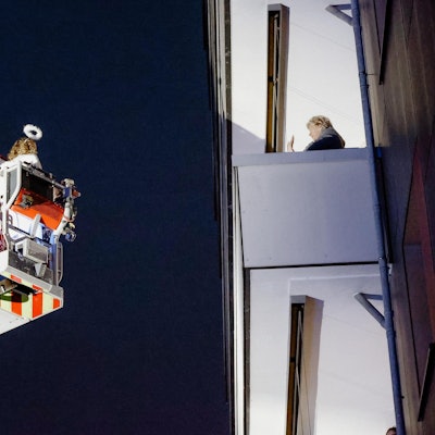 Der Weihnachtsmann grüßt eine Frau, er ist mit einer Drehleiter unterwegs.
