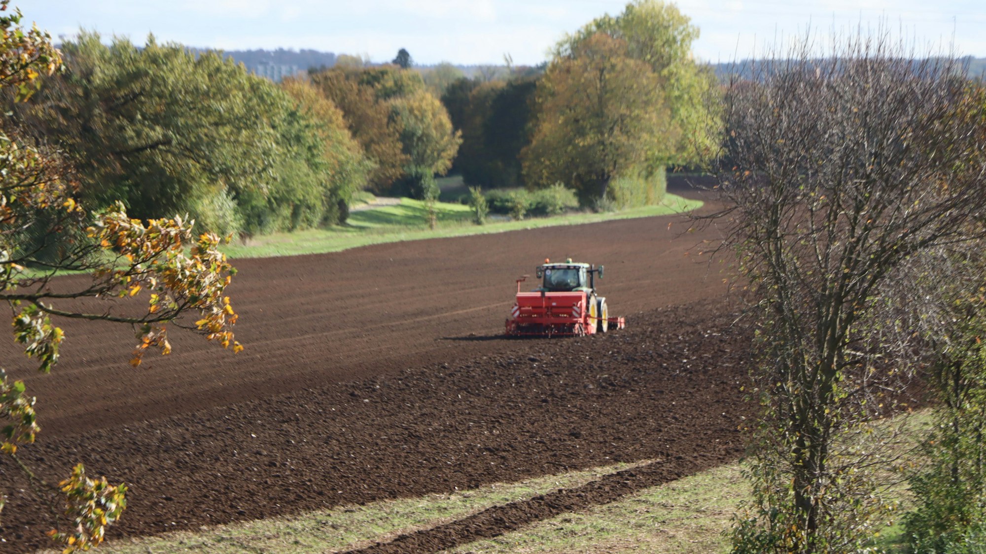 Zu sehen ist ein Traktor auf einem Feld.