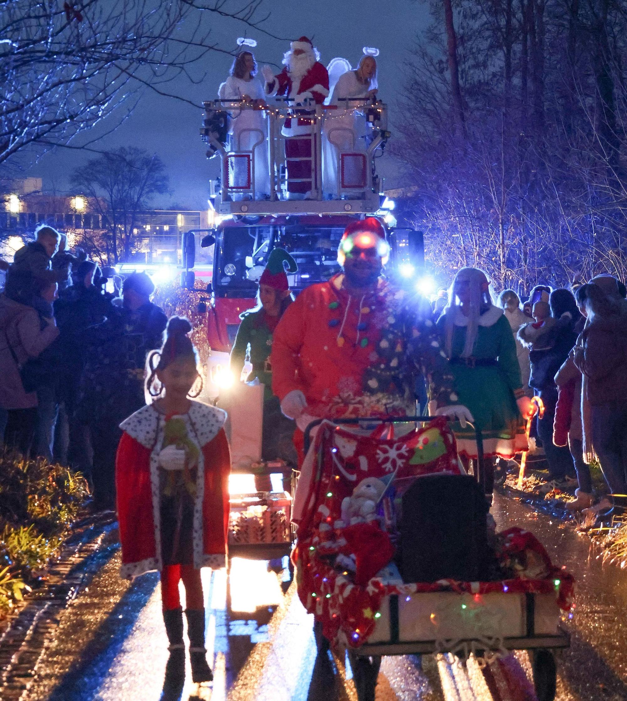 Oktay Bahar schiebt einen Wagen mit Präsenten, im Hintergrund sind Weihnachtsmann und Engel auf der Drehleiter zu sehen.