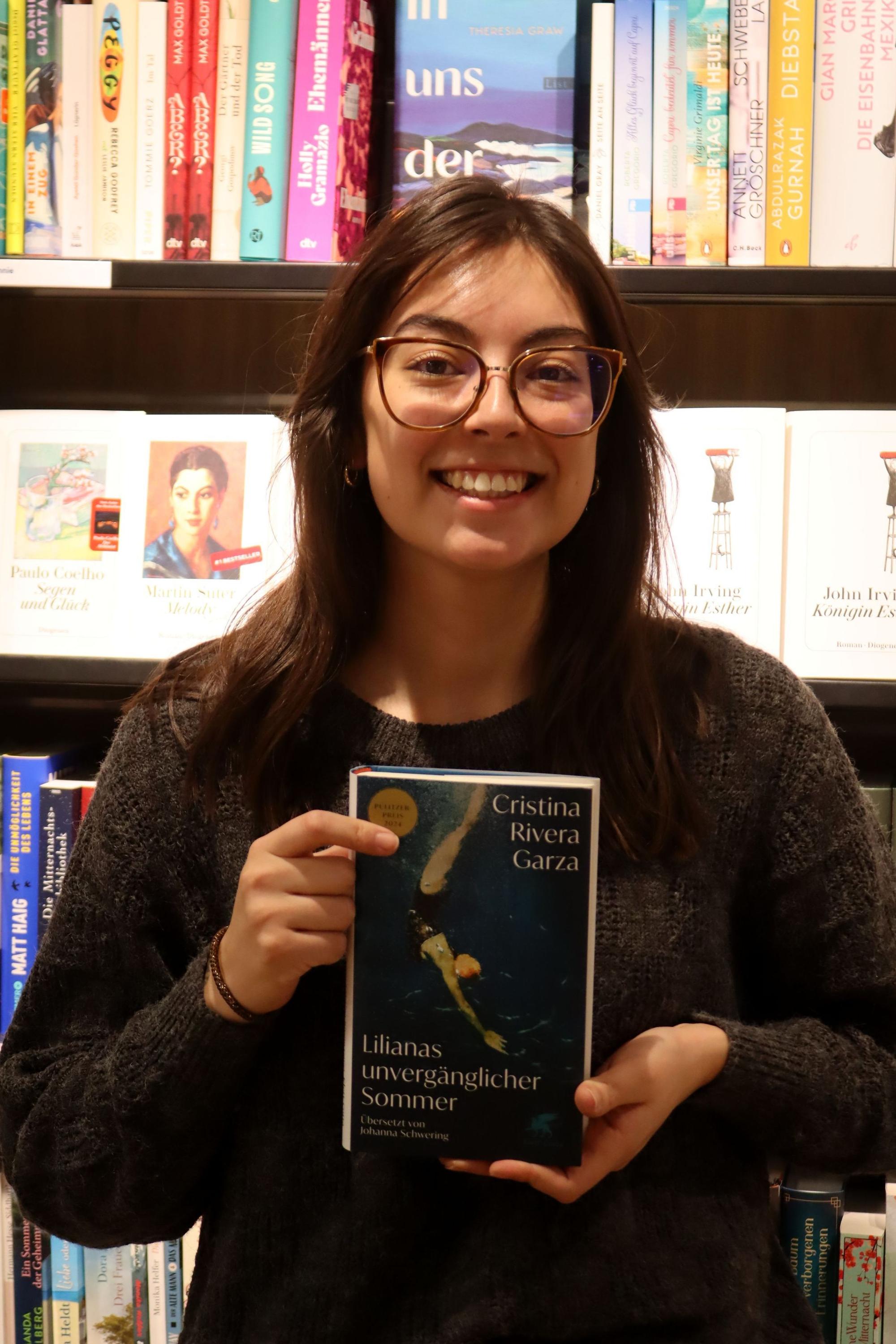 Das Bild zeigt Laetitia Paez Niezgoda mit ihrem Lieblingsbuch in der Hand.