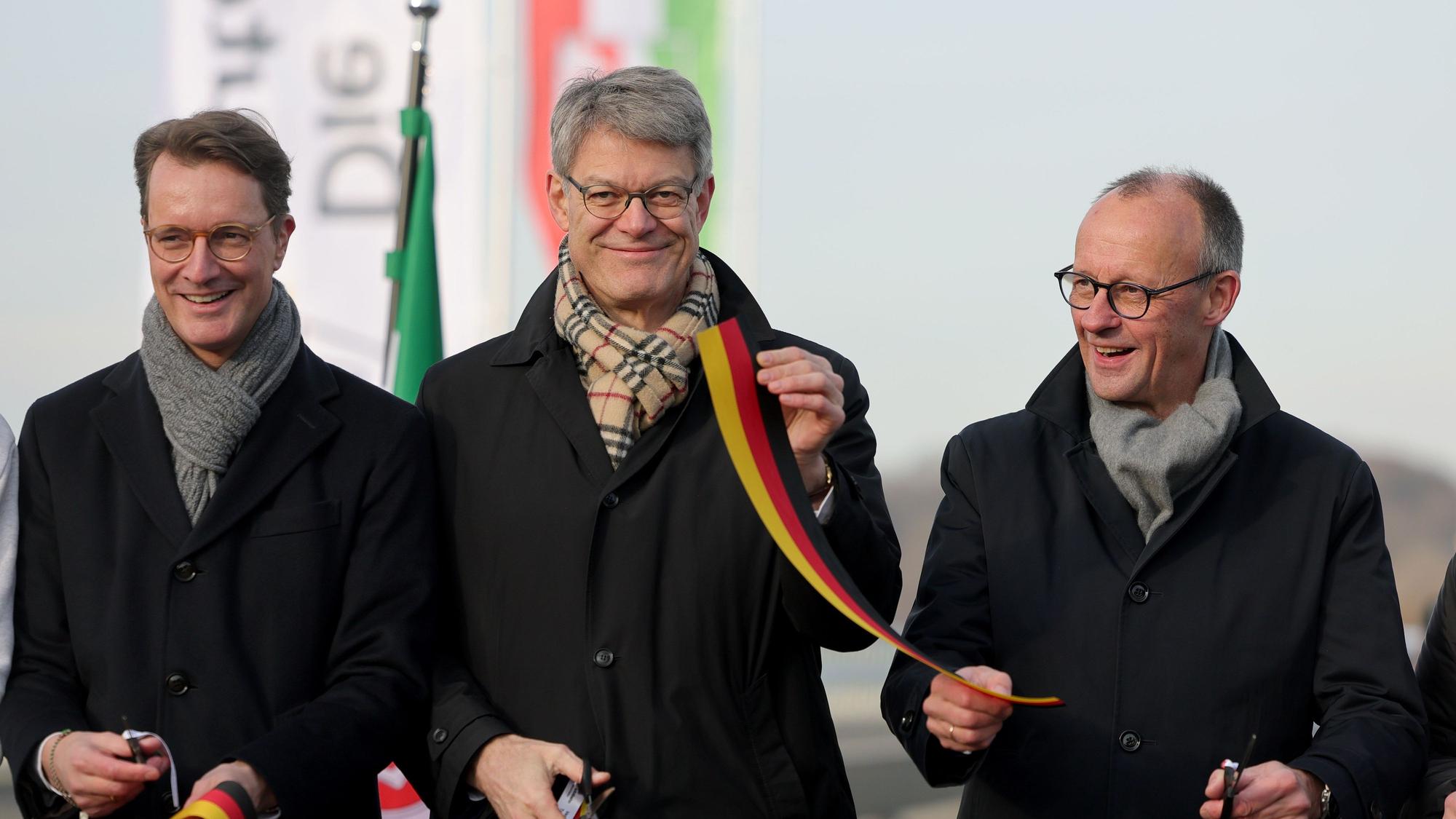 Hendrik Wüst (l-r, CDU), Ministerpräsident Nordrhein-Westfalen, Bundesverkehrsminister Patrick Schnieder (CDU) und Bundeskanzler Friedrich Merz (CDU) durchschneiden ein Band bei der Eröffnung der Rahmedetalbrücke.