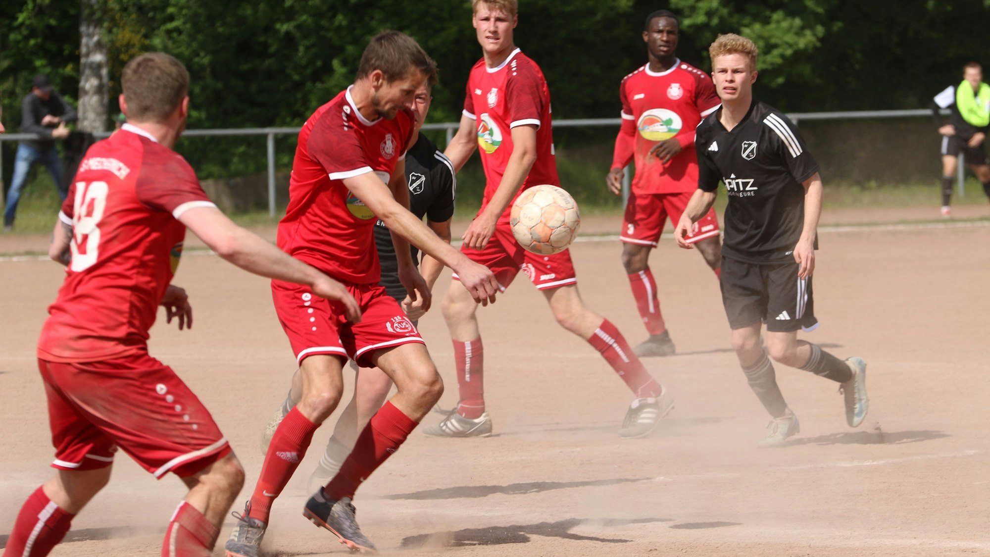 Jens Honnef schaut auf den Ball. Die Asche im Eifelstadion staubt.