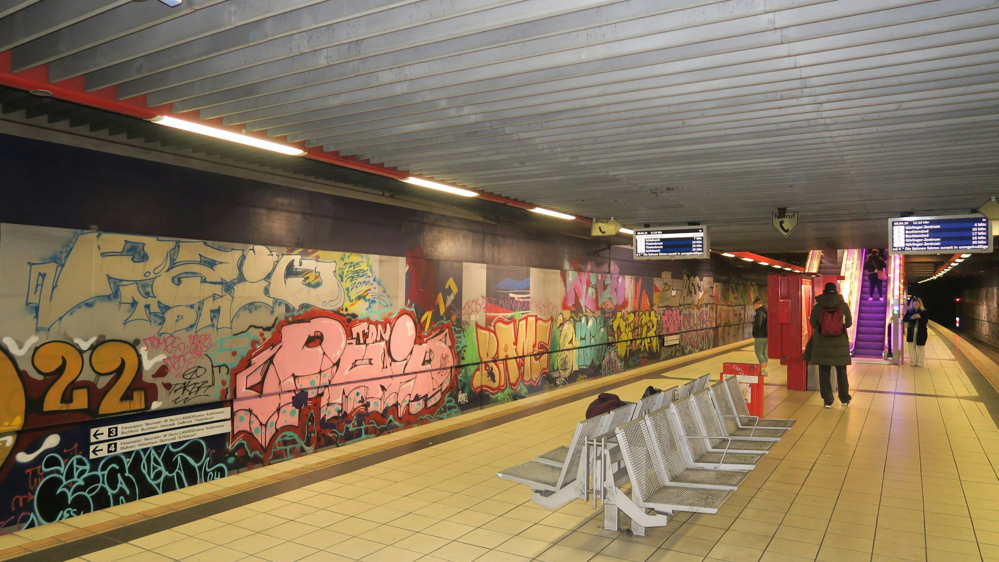 Eine Wand an einer U-Bahn-Haltestelle ist mit Graffiti besprüht.