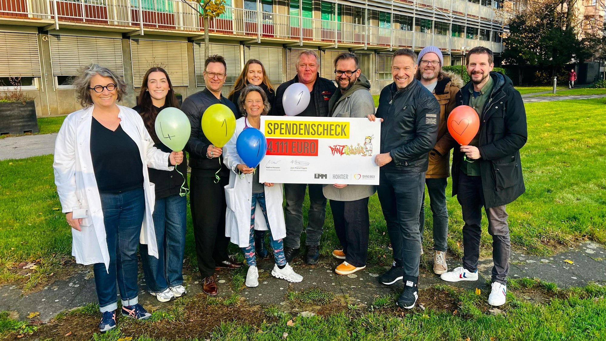Patrick Lück, Jens Streifling und Freddi Lubitz-Ragland von der Band überreichen mit Carglass-Mitarbeiter Rolf Blaschke die Spende.