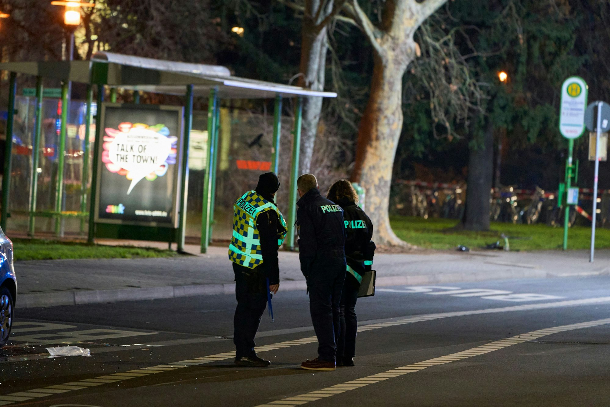 Einsatzkräfte der Polizei stehen an einer Bushaltestelle in der Innenstadt Gießens.