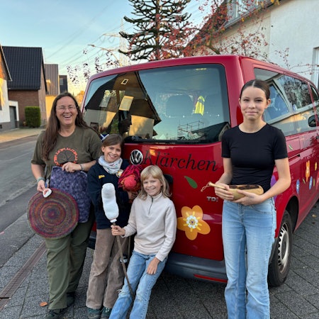 Ingrid Retterath und ihre drei Töchter stehen am VW-Bus der Familie, auf dem „Klärchen“ geschrieben steht.