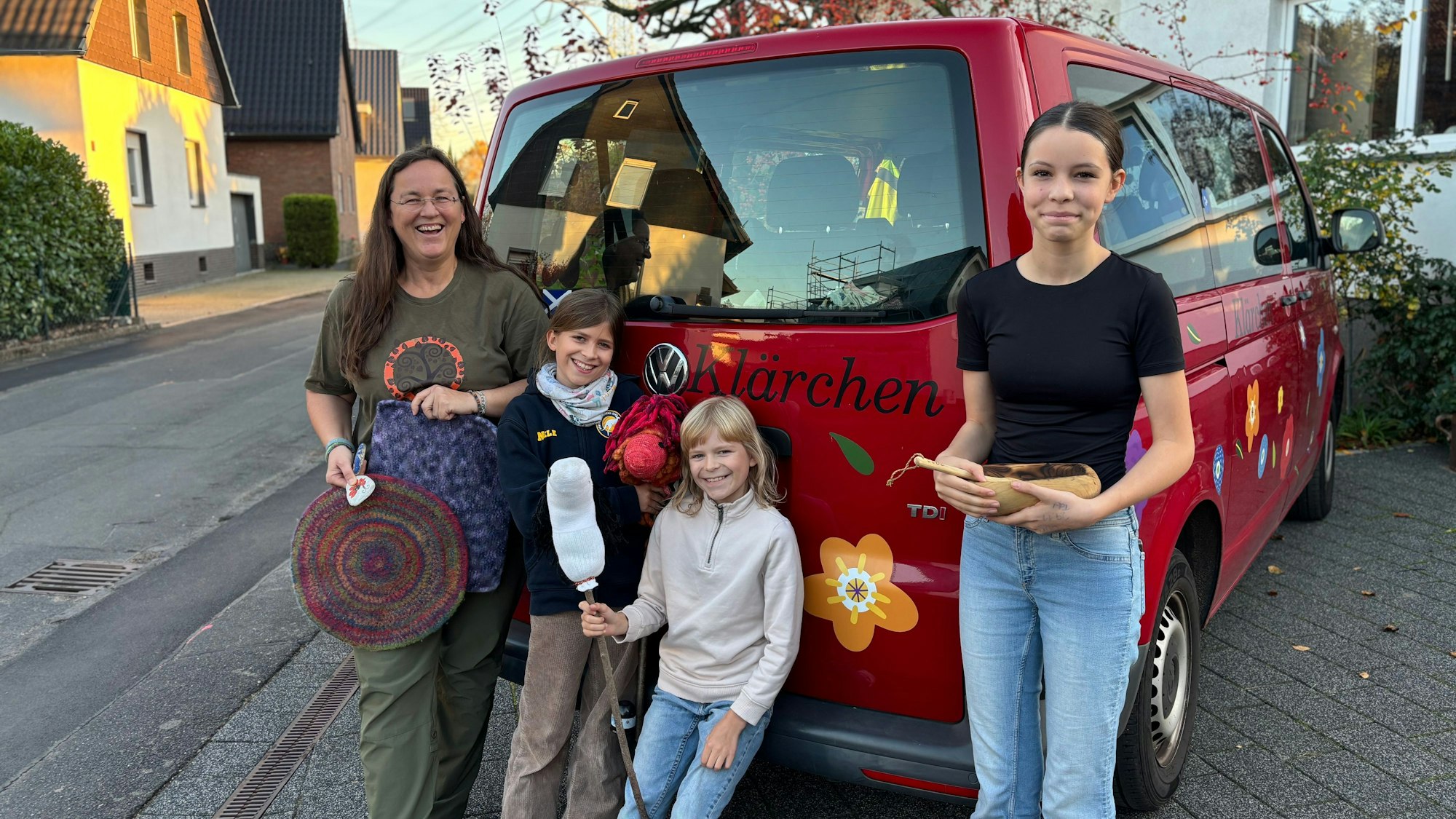 Ingrid Retterath und ihre drei Töchter stehen am VW-Bus der Familie, auf dem „Klärchen“ geschrieben steht.