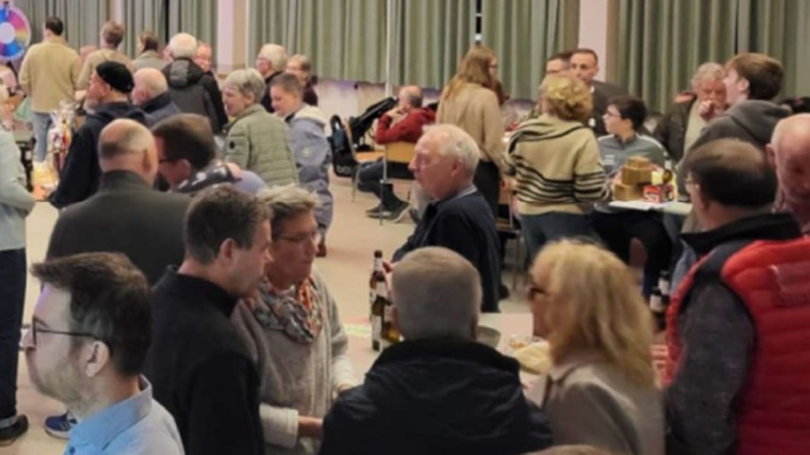 Blick in einen Saal, in dem sich Menschen unterhalten