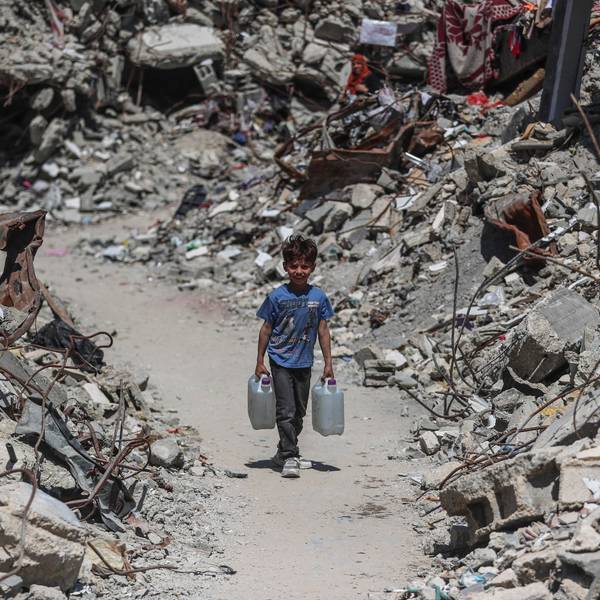 Das Symbolbild zeigt einen palästinensischen Jungen, der Wasser im Flüchtlingslager Jabalia im nördlichen Gazastreifen holt. Links und rechts von ihm türmt sich der Schutt zerstörter Häuser.