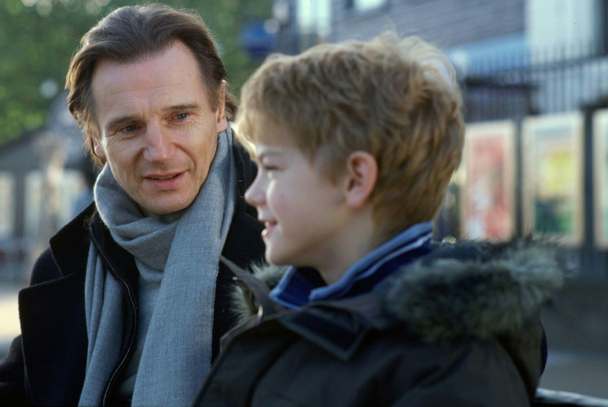 Sam (Thomas Brodie Sangster, rechts) versucht mit Hilfe seine Stiefvaters (Liam Neeson) alles, damit sich die amerikanische Austauschschülerin Joanna in ihn verliebt. (Bild: Universal Studios)