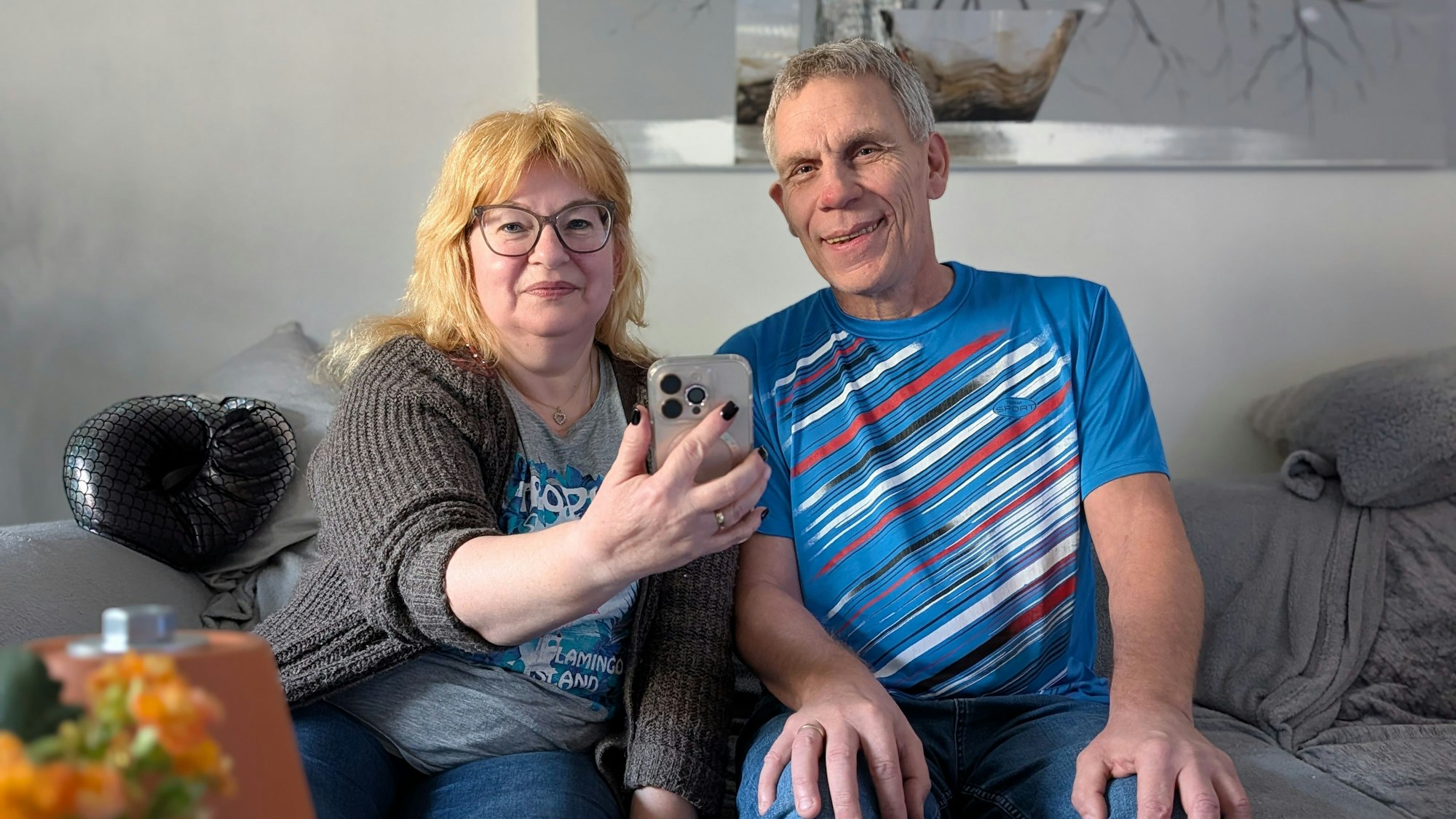 Das Foto zeigt das Ehepaar Klein, das sich die Kurznachricht auf dem Mobiltelefon anschaut.