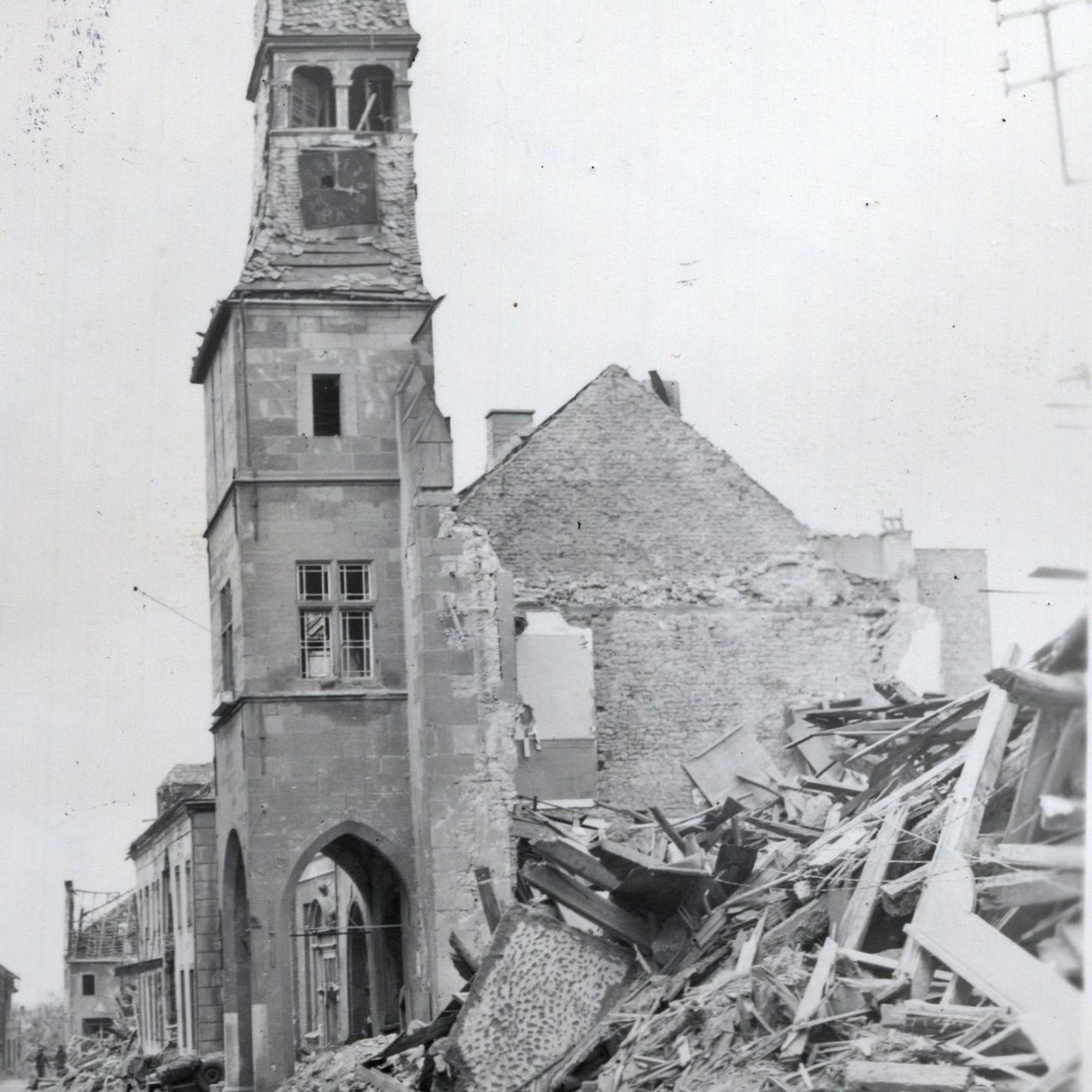 Der Rathausturm ragt aus einem Schuttberg hervor.