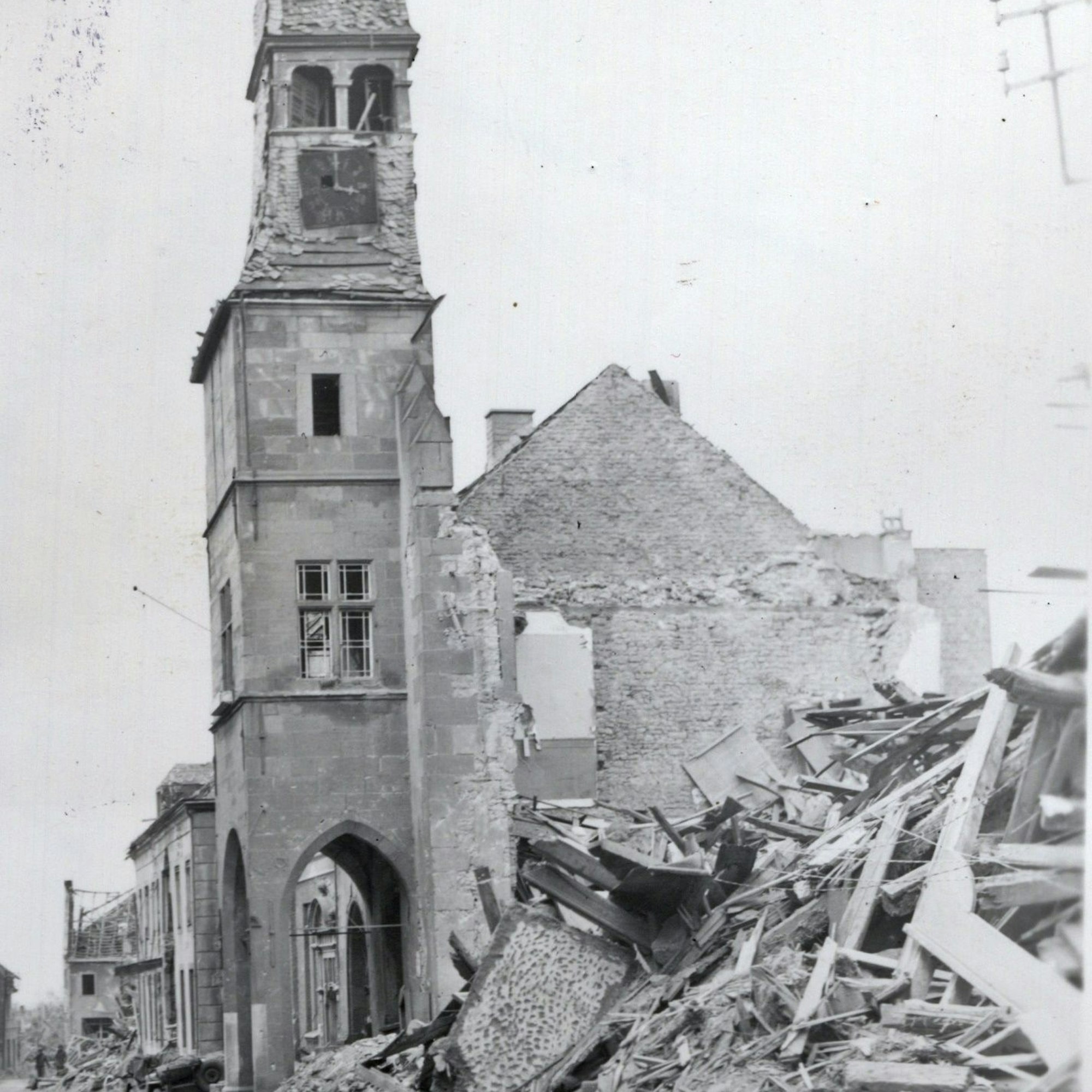 Der Rathausturm ragt aus einem Schuttberg hervor.