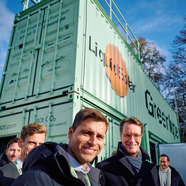 Der NRW-Ministerpräsident steht mit Vertretern von Greenlyte vor einen grünen Container.