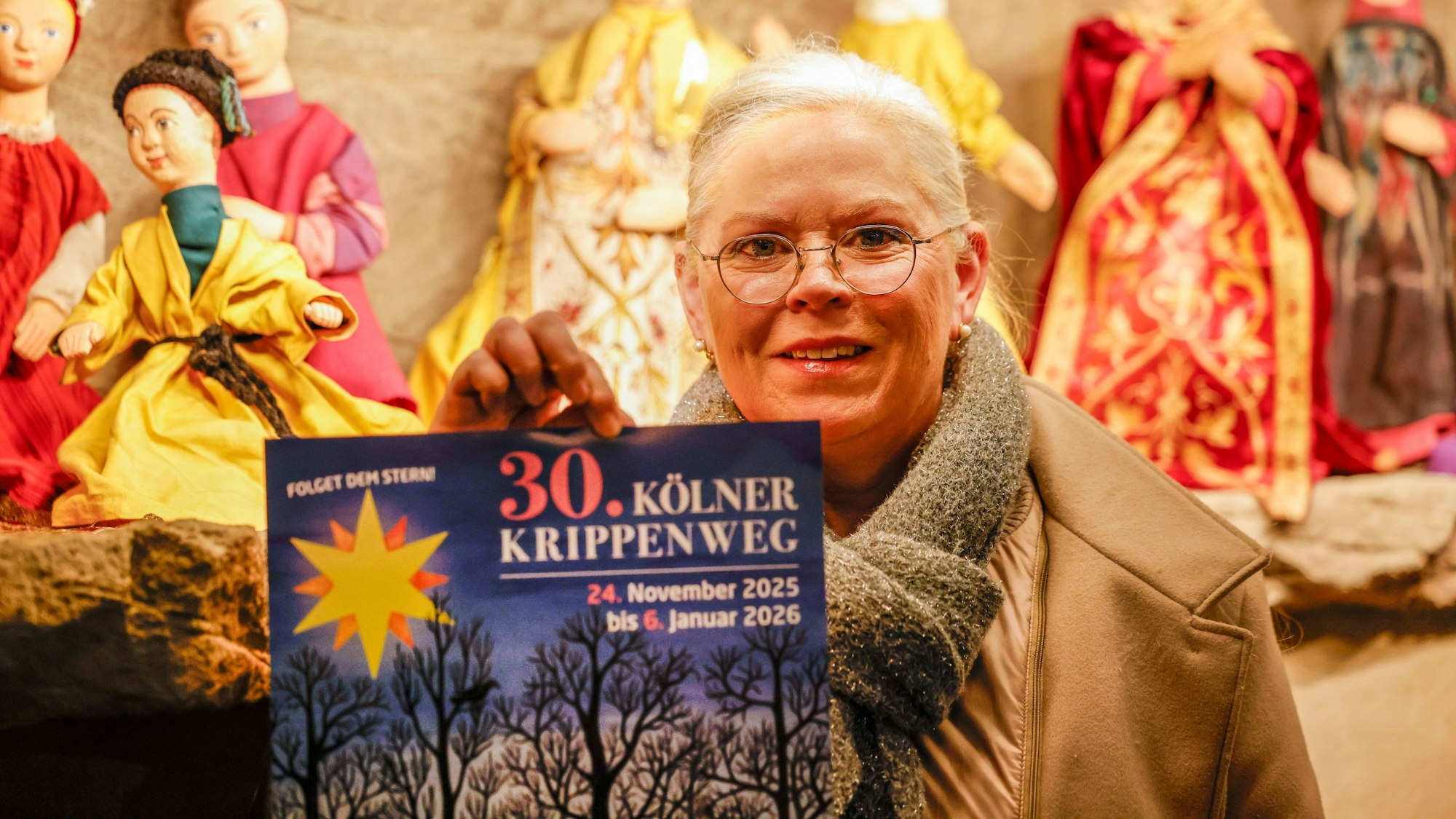 Caroline Maria Weber hält eine Broschüre zum Kölner Krippenweg. Sie ist die Vorsitzende der Landesgemeinschaft der Krippenfreunde in Rheinland und Westfalen. Sie organisiert die Krippenwege in Köln und Aachen.