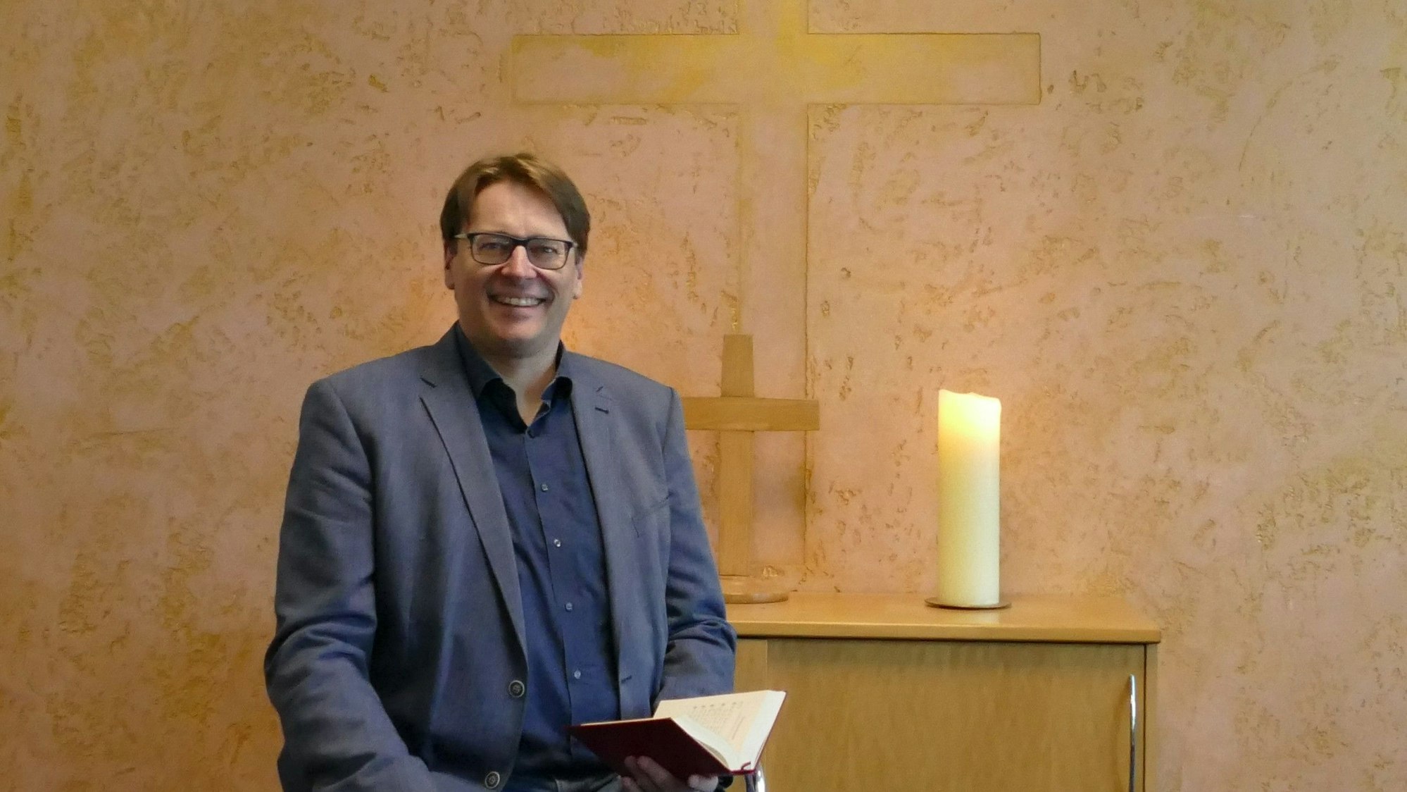 Ein Mann vor einem Altar.