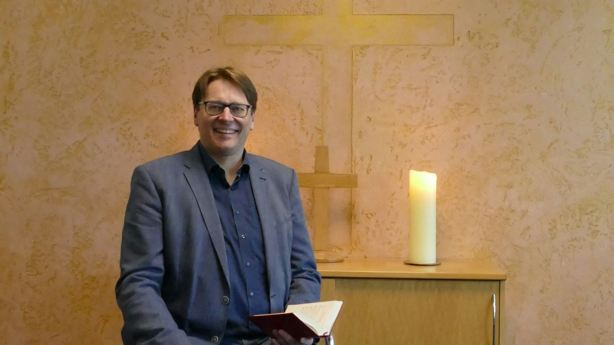 Ein Mann vor einem Altar.