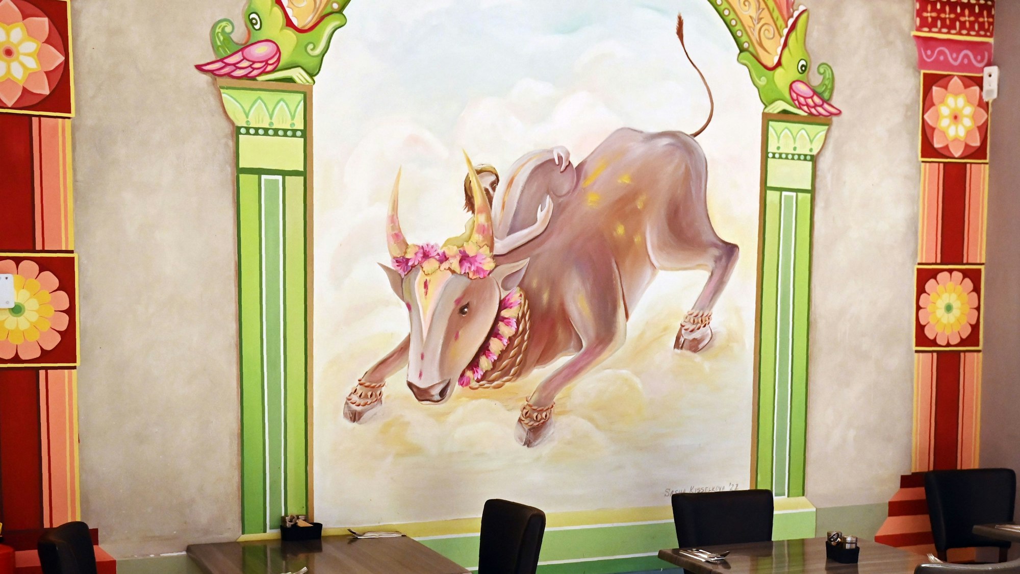 Wandgemälde mit weißem Rind zwischen grünen Säulen