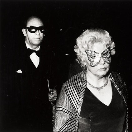 Ein maskiertes Paar schaut skeptisch in die Kamera des Fotografen.