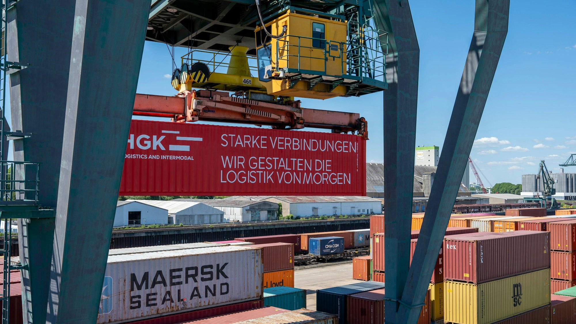 Ein Kran im Niehler Hafen hebt einen Container mit der Aufschrift "Starke Verbindungen. Wir gestalten die Logistik von morgen."