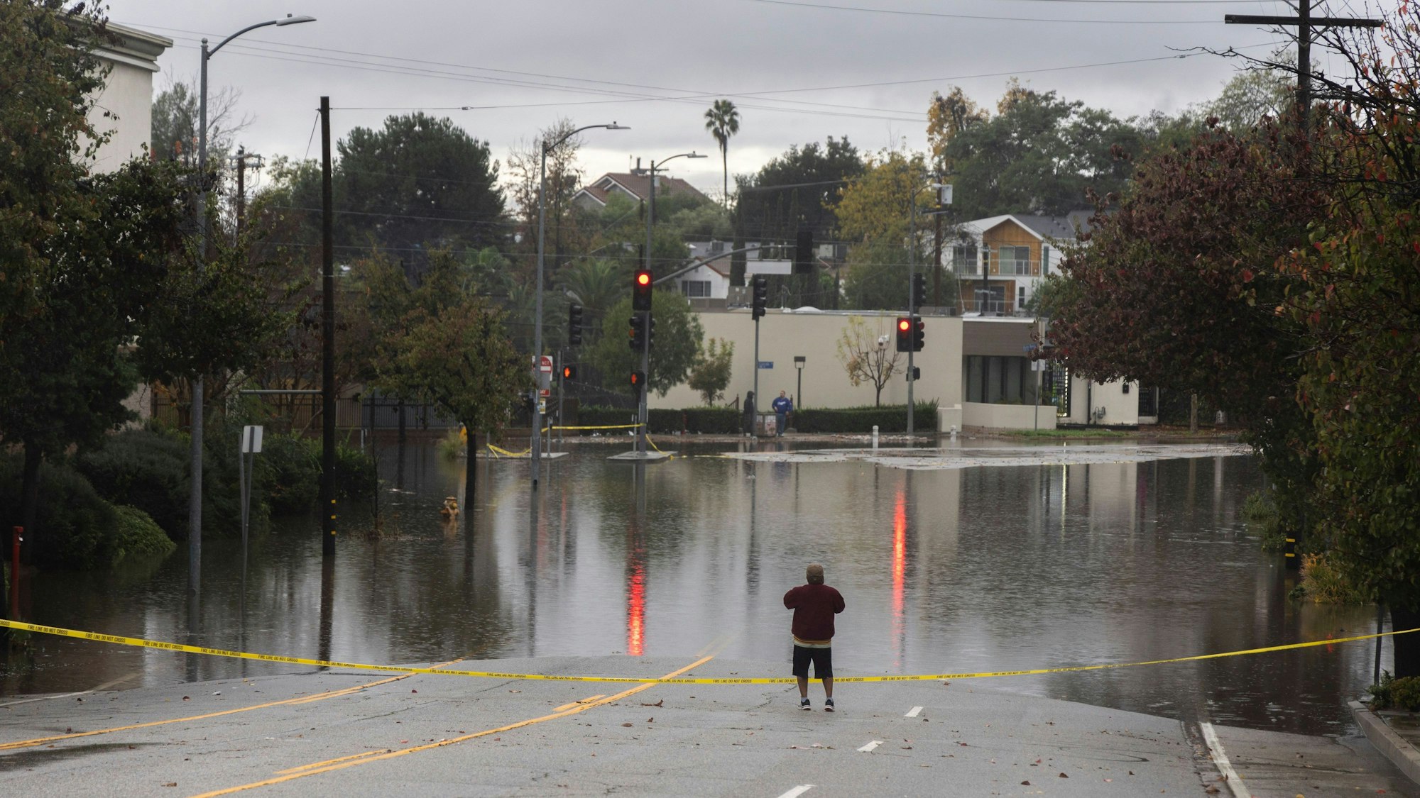 Ein Mann blickt auf eine überflutete Kreuzung im Stadtteil South Pasadena von Los Angeles.