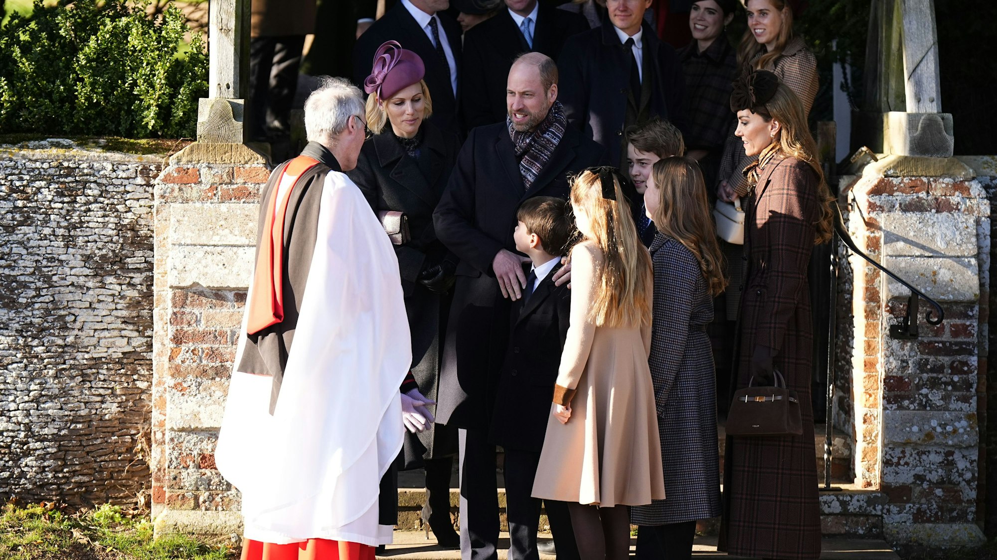Zara Tindall (vorne, zweite von links nach rechts), William, Prinz von Wales, Prinz Louis, Prinzessin Charlotte, Prinz George, Mia Tindall und Catherine, Prinzessin von Wales sowie (hinten, von links nach rechts) Mike Tindall, Jack Brooksbank, Edoardo Mapelli Mozzi, Prinzessin Eugenie und Prinzessin Beatrice verlassen den Weihnachtsgottesdienst in der St. Mary Magdalene Church.