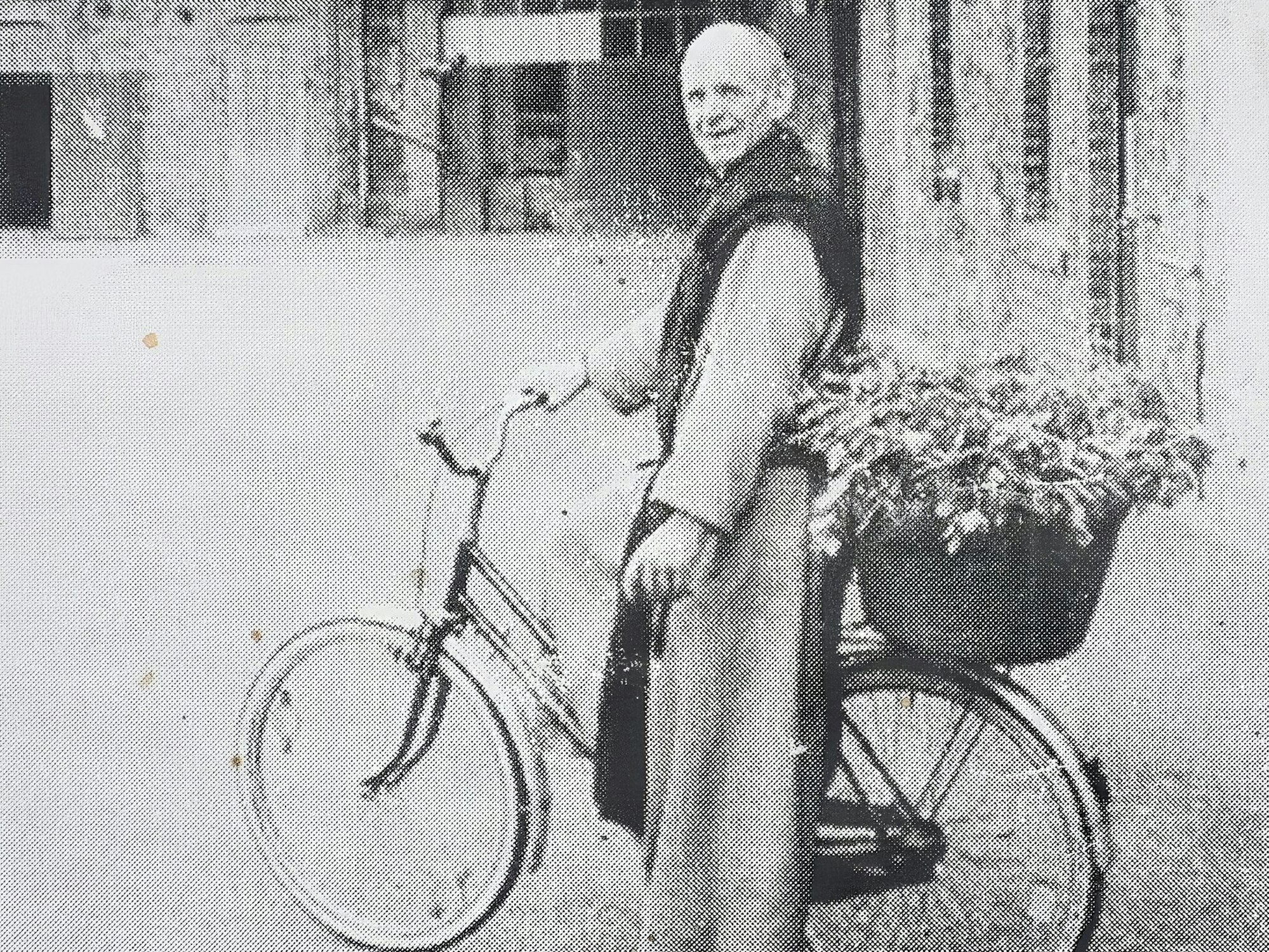 Ein altes Foto von Bruder Clemens, wie er mit seinem Fahhrad im Innenhof von Kloster Mariawald steht, auf dem Träger hat er einen Korb voller Gemüse.
