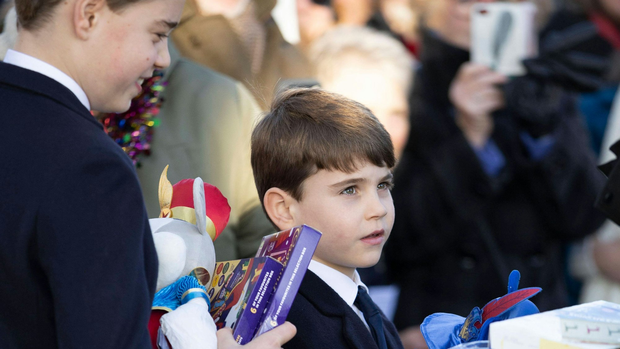 Prinz George und Prinz Louis nehmen Geschenke an.