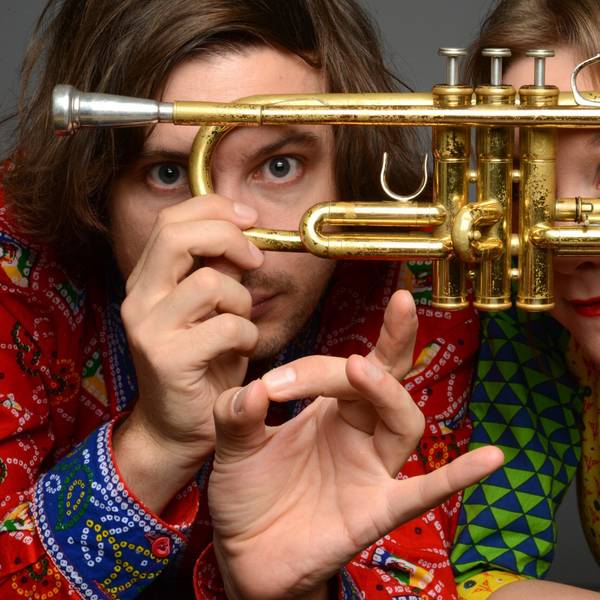 Die Kölner Jazz-Musiker Tamara Lukasheva und Matthias Schriefl schauen durch eine Trompete.