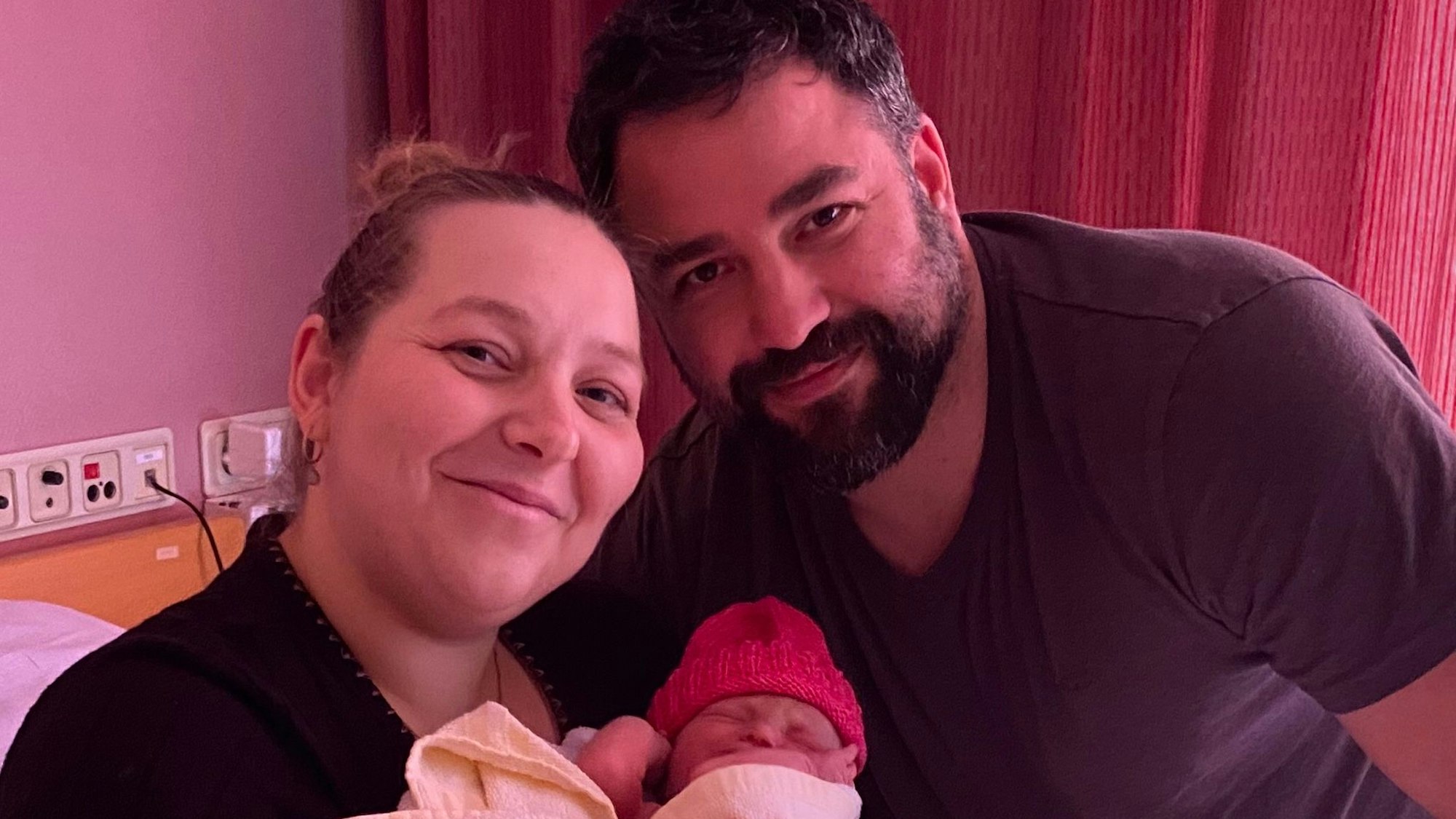 Mutter und Vater mit einem Neugeborenen.