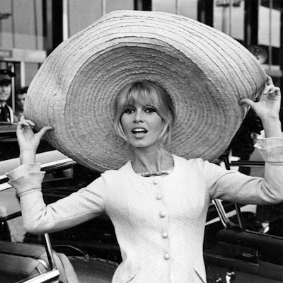 Die französische Schauspielerin Brigitte Bardot posiert mit einem riesigen Sombrero, den sie aus Mexiko mitgebracht hat, als sie am 27. Mai 1965 am Flughafen Orly in Paris, Frankreich, ankommt.