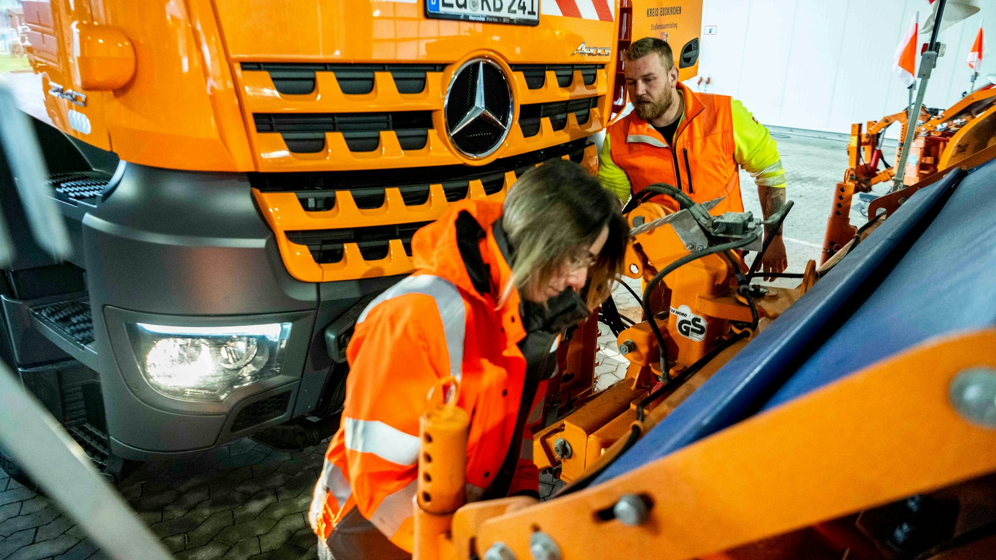 Zusammen mit einem Kollegen prüft Eva Heinen die Montage eines Räumschilds.