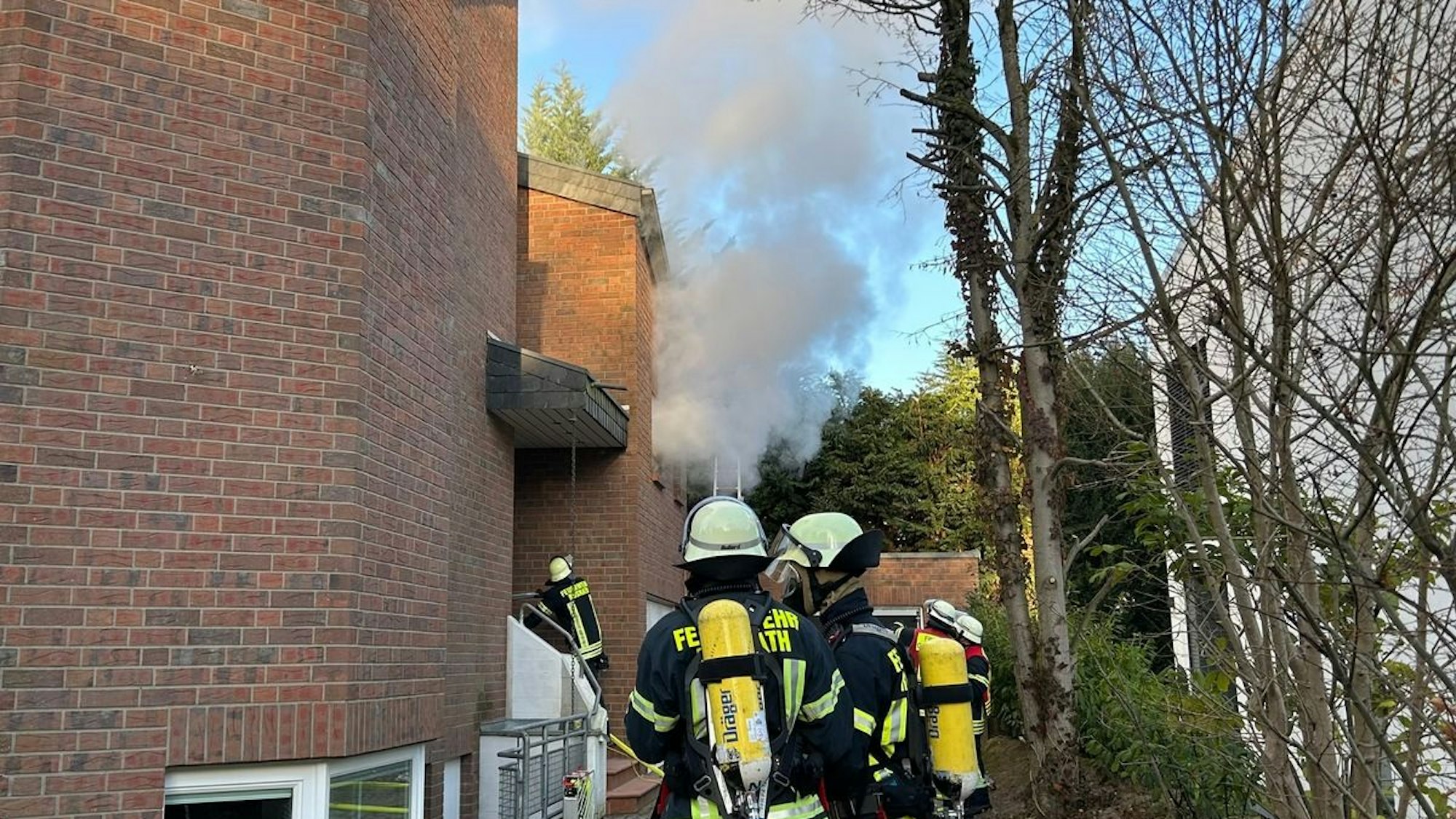 Feuerwehrleute bei Löscharbeiten an einem brennenden Dachstuhl in Rösrath.